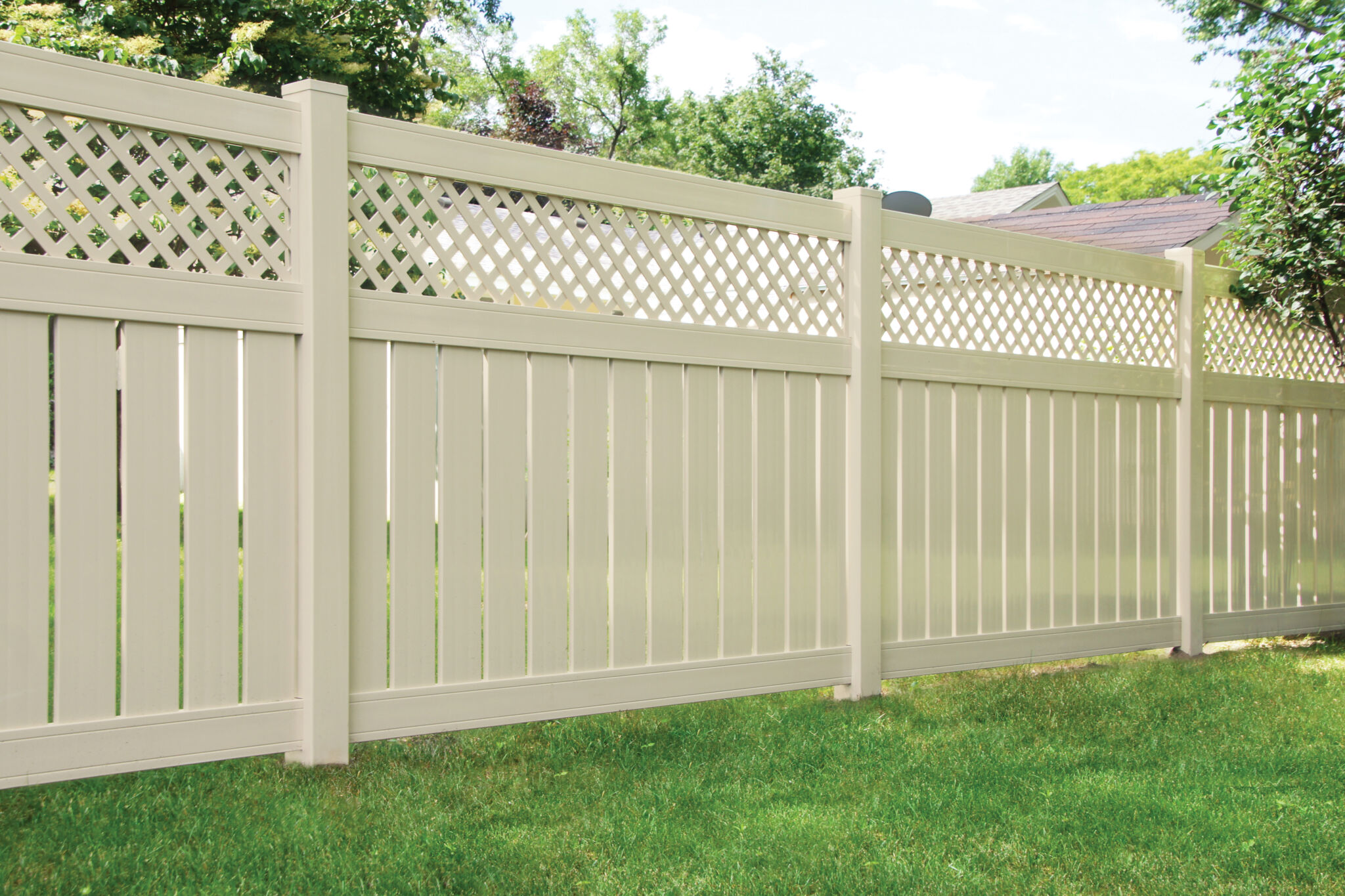 Tan vinyl privacy fence with lattice top